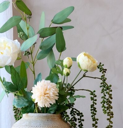 Foto på blomsterarrangemang i kruka med gröna rankor