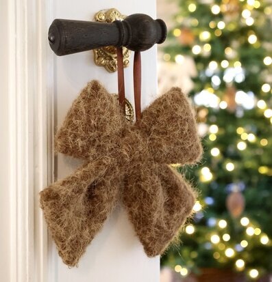 Foto: Beige rosett på dörrhandtag med julgran bokeh