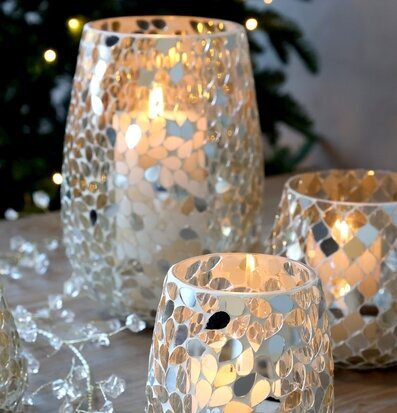 Foto: Mosaikglaslyktor med tända ljus och granbokeh
