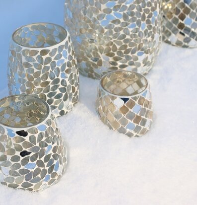 Bild på mosaiklyktor i glas på snö i solsken
