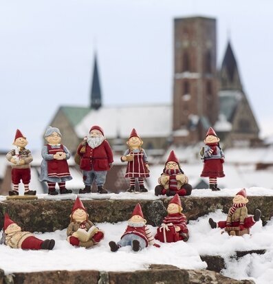 Foto: Tomtefigurer på snöiga trappsteg vid kyrka