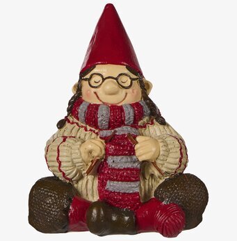 Foto av tomtefigur som stickar med garnnystan vit bakgrund