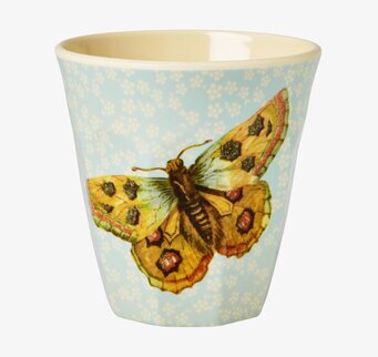 Bild av mugg med fjärilsmotiv och blommig bakgrund