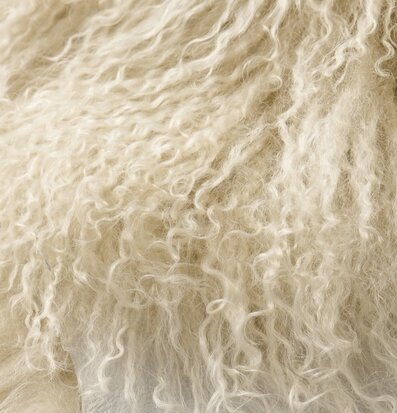 Foto: Närbild av gräddvitt lockigt lammskinn ulltextur