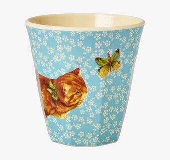 Bild av färgglad mugg med katt och blommor i livlig design