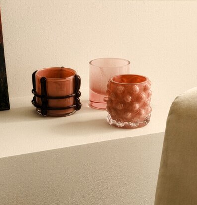 Bild: Rosa ljuskoppar i glas på beige putsavsats