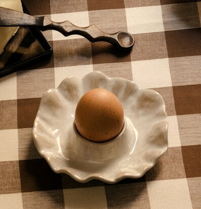 Foto: Ägg i äggkopp på rutduk vid frukostbordet