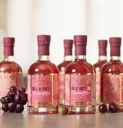 Foto av rosé balsamvinägerflaskor med druvor i studio