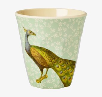 Bild av mugg med påfågelmotiv och blommig bakgrund