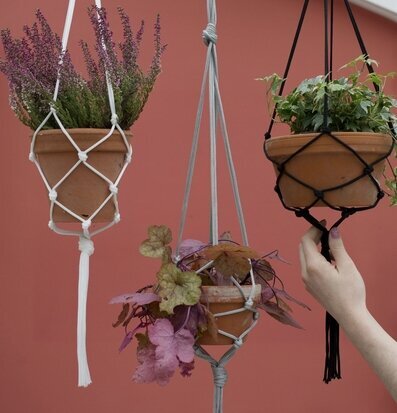 Bild av dekorativa hängkrukor med växter i makramé