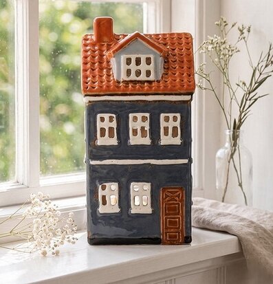 Foto: Blå keramikljuslykta hus på fönsterbräda