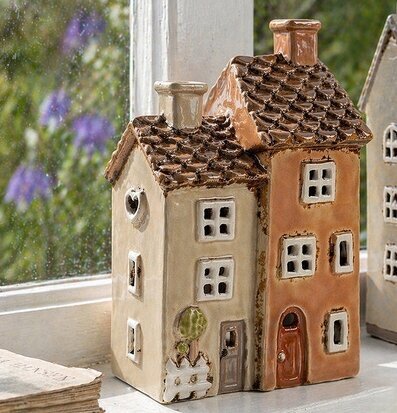 Foto: Keramisk ljuslykta hus rosa/beige i fönster