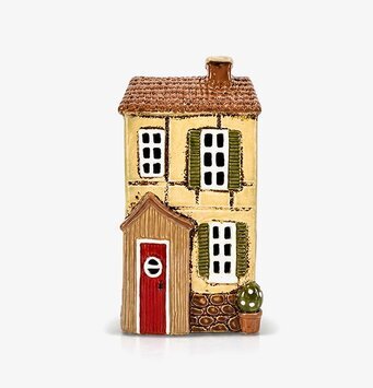 Foto: Gul ljuslykta hus i keramik med gröna luckor