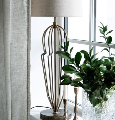 Foto: Bordslampa i antik mässing vid fönsterbräda