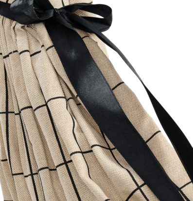 Foto: Beige plisserat tyg med svart rosett och rutor