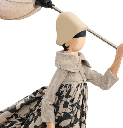 Foto: Närbild av figurlampa i trä och textil, vit bakgrund