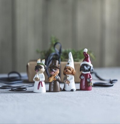 Foto: Luciatåg med fyra hundfigurer på textilbord