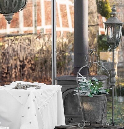 Bild av veranda med krukställning, växt och lykta
