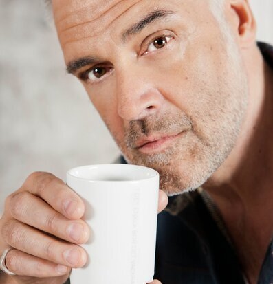 Bild av en person med vit mugg i avslappnad stund