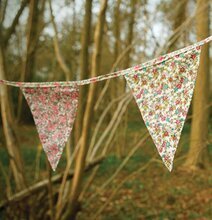 Bild av vimplar med blommönster i en skogsmiljö