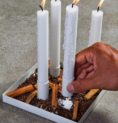 Bild av ljushållare med tända ljus och krydddekoration