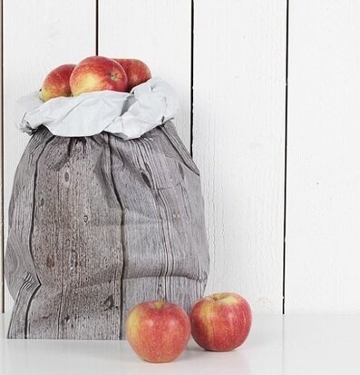 Bild av elegant presentpåse med trädesign och röda äpplen