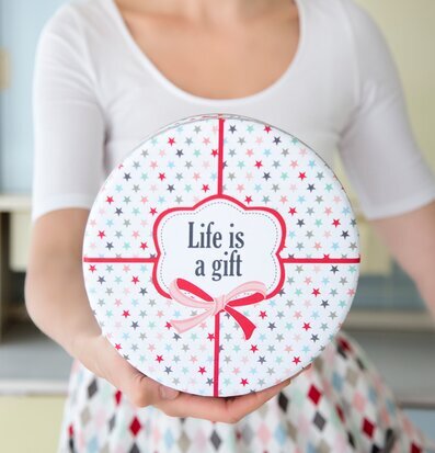 Bild av kvinna med dekorativ plåtlåda och inspirerande text