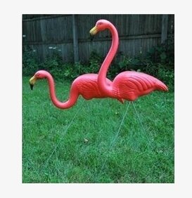 Foto av livfulla rosa flamingos i trädgårdsdekoration