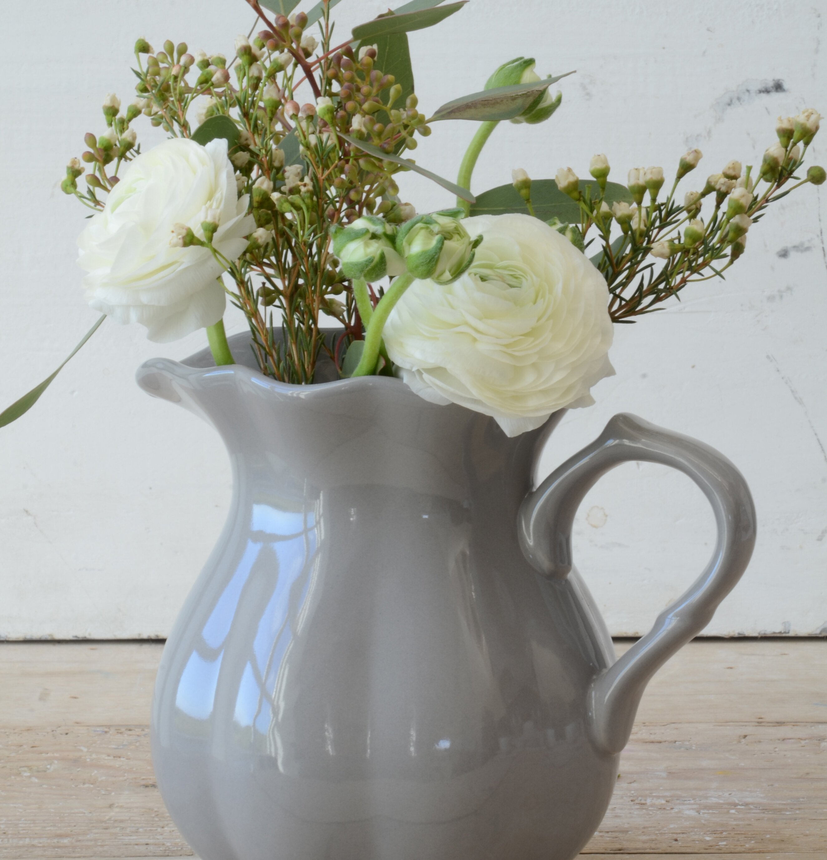 Bild av elegant grå kanna med blommor och grönt