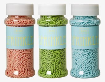 Bild av färgglada strössel i tre genomskinliga burkar