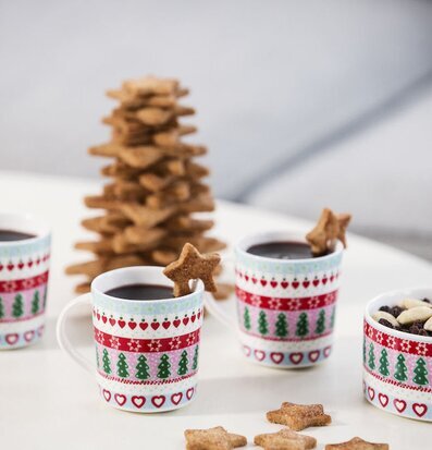 Bild av vintermuggar med julmönster och pepparkakor