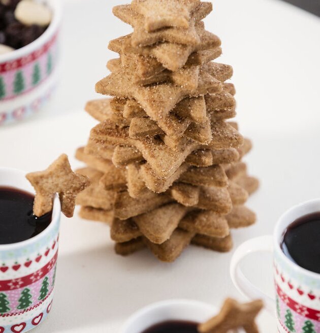 Bild av julinspirerad scen med glöggmuggar och pepparkakor