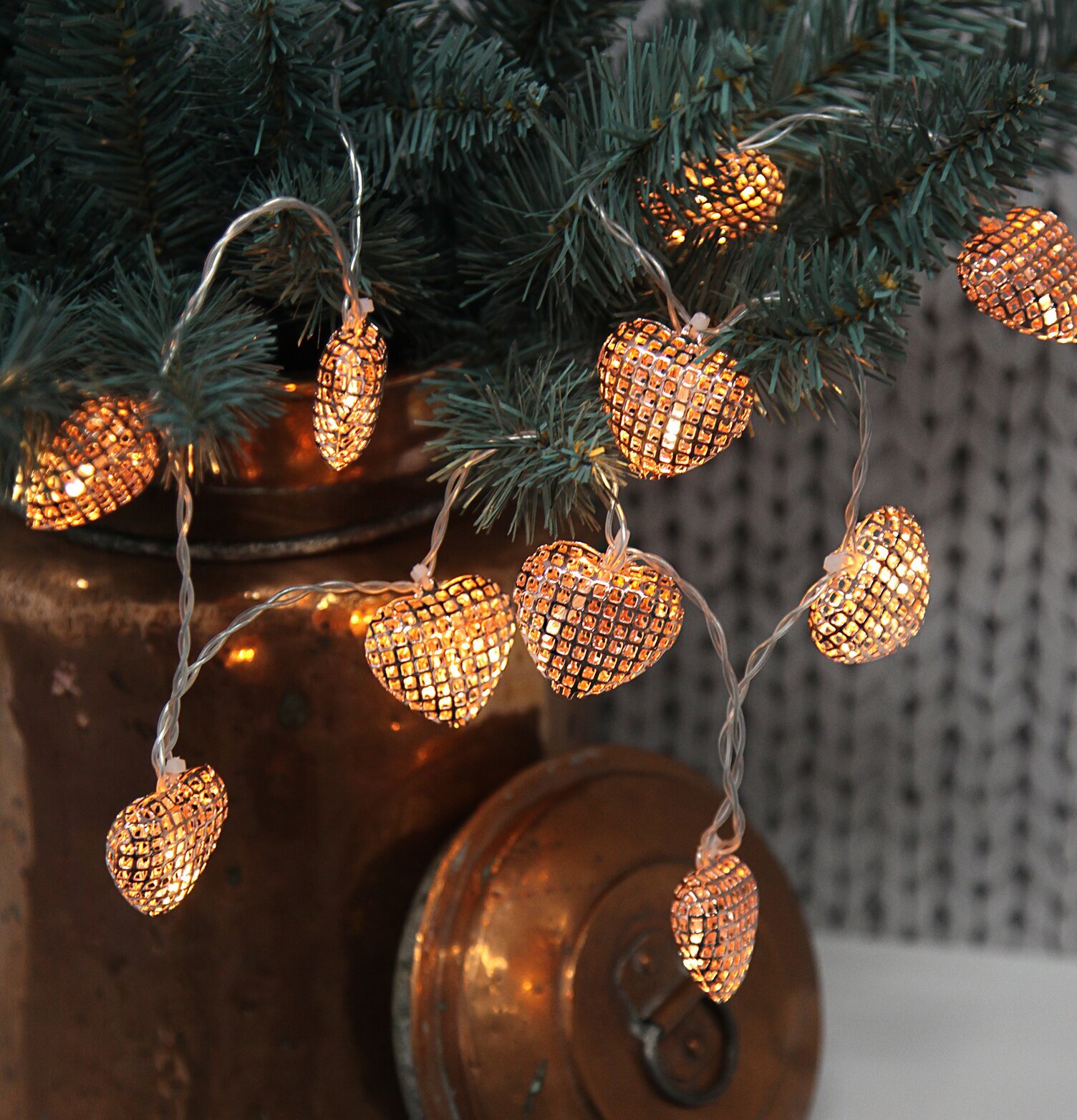 Bild av dekorativ ljusslinga med kopparfärgade hjärtan