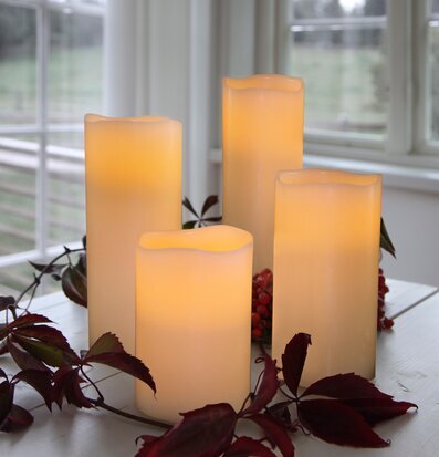 Bild av eleganta elfenbensvita LED-vaxljus i höstmiljö
