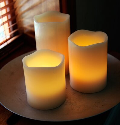 Foto av tre vaxljus på metallfat i harmonisk miljö