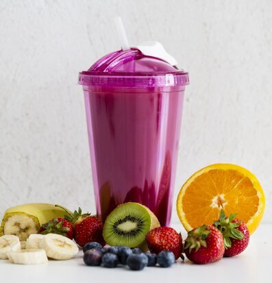 Bild av rosa smoothiemugg med färsk frukt runtomkring