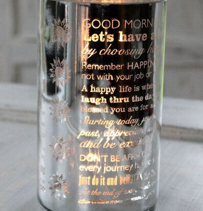 Bild av dekorativ ljuslykta med text och blommönster