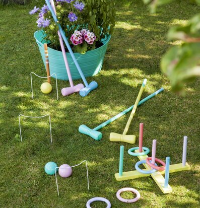 Bild av färgglatt krocketspel i somrig trädgårdsmiljö