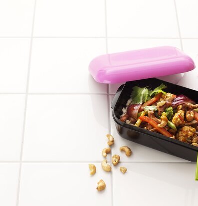 Bild av stilren matlåda med färgglad måltid och tillbehör