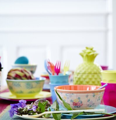 Bild av färgglad dukning med blommor och köksredskap