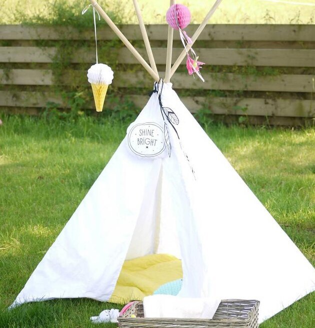 Bild av charmigt tipi-tält i grönskande utemiljö