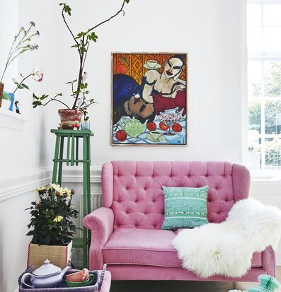 Bild av smakfullt inrett vardagsrum med rosa sammetsoffa