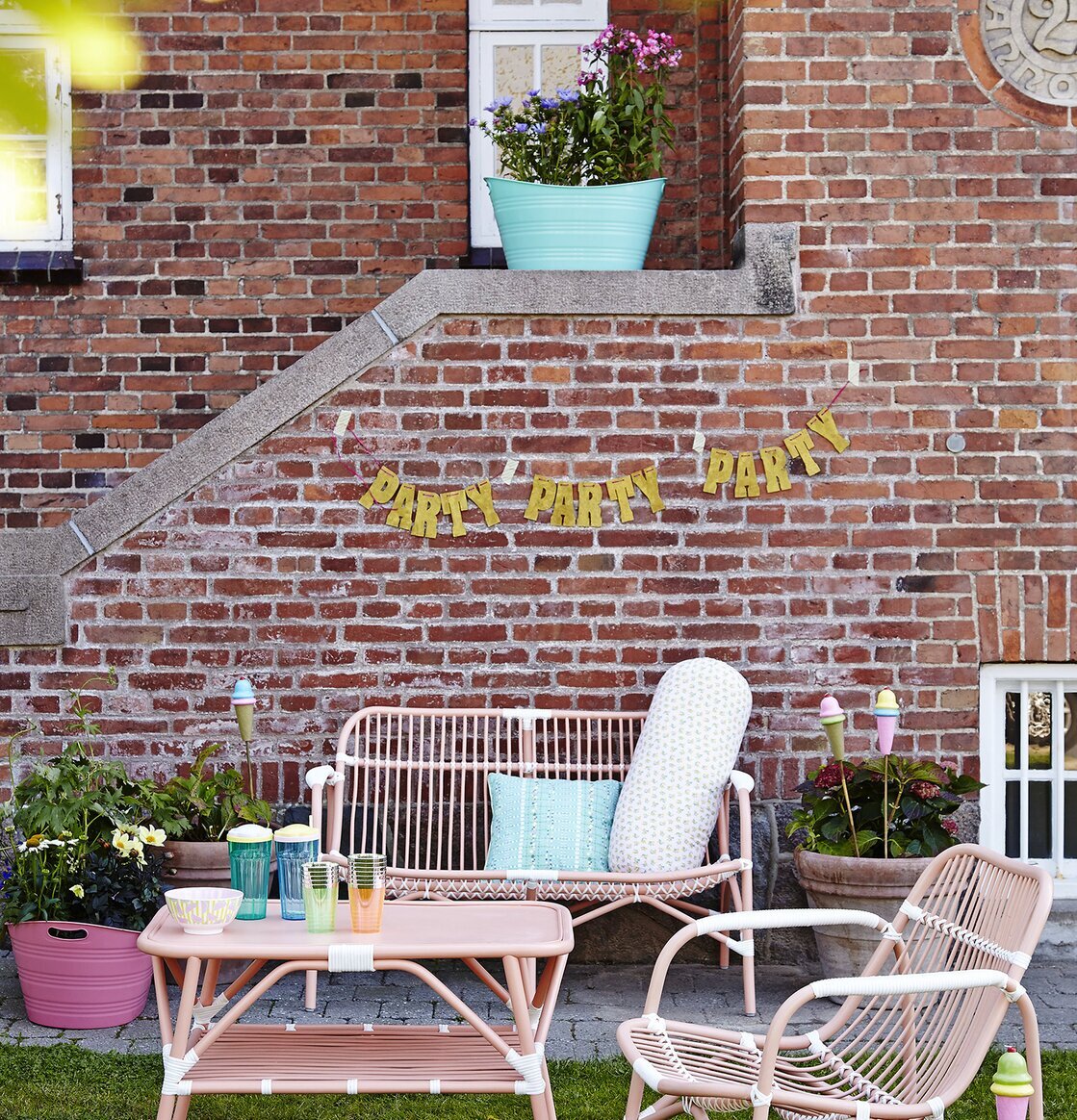 Cane Coffee Table Soft Coral från Rice i trädgårdsmiljö
