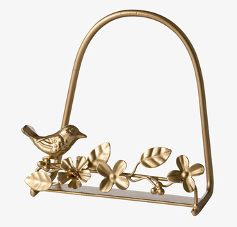 Foto av gyllene tallrik- och servettställ med fågel