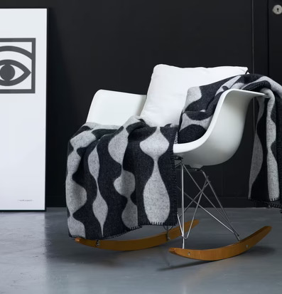 Bild av stilren interiör med modern gungstol och filt