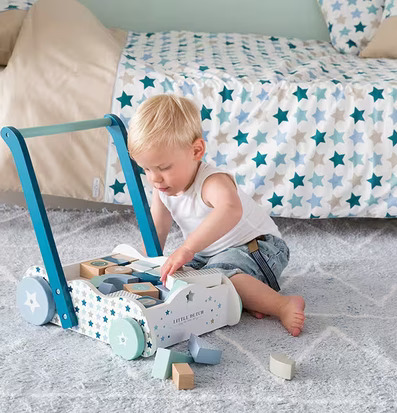 Bild av pojke som leker med stilren gåvagn i barnrum