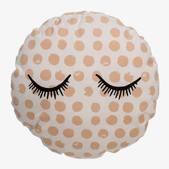 Bild av rund kudde med prickar och tecknade ögonfransar