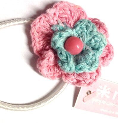 Bild av detaljrik hårsnodd med virkad blomma