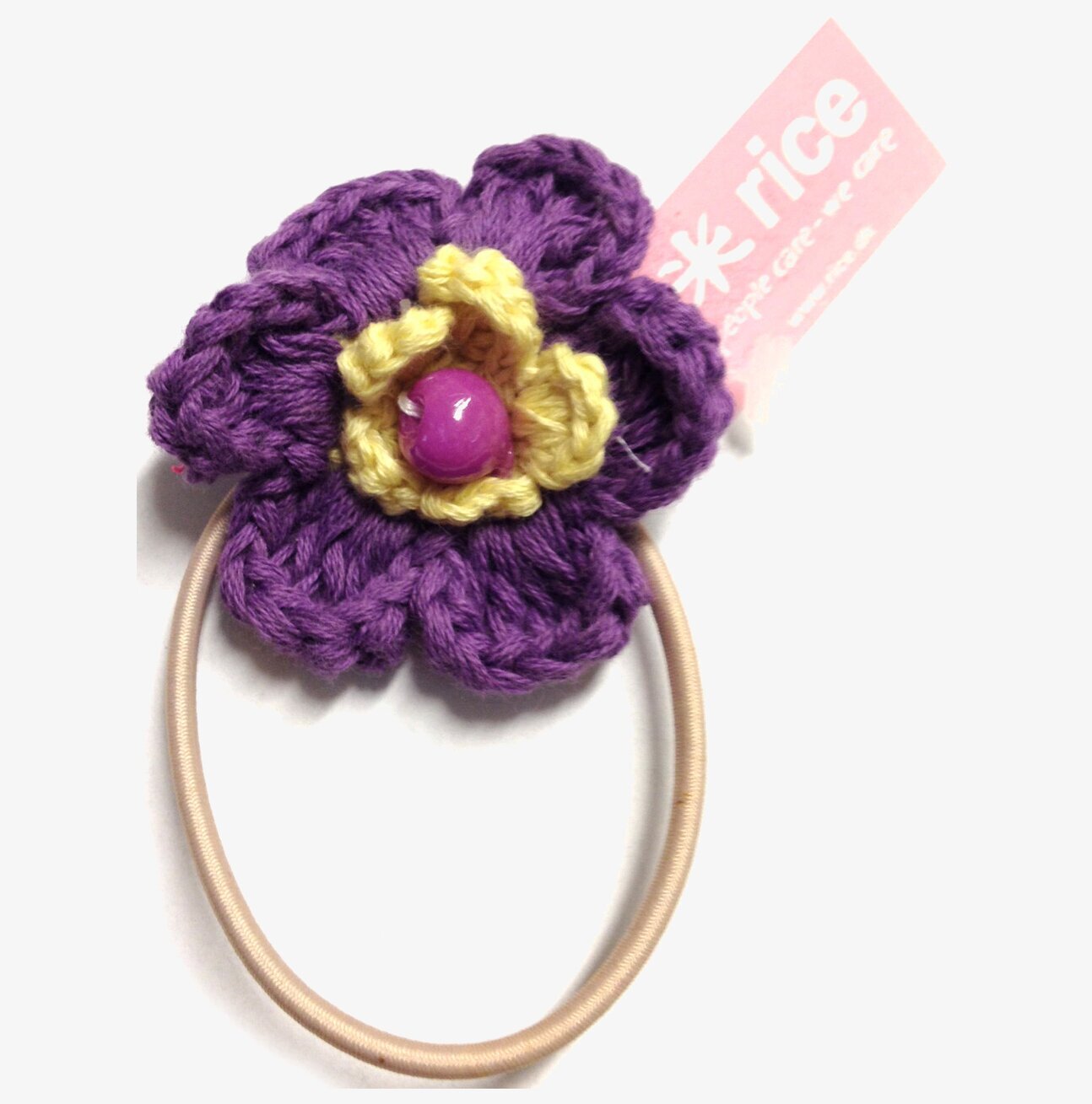 Bild av färgglad hårsnodd med virkad blomdesign