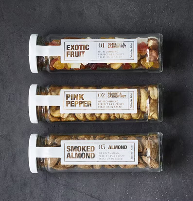 Foto av eleganta glasburkar med nöt- och fruktmixar